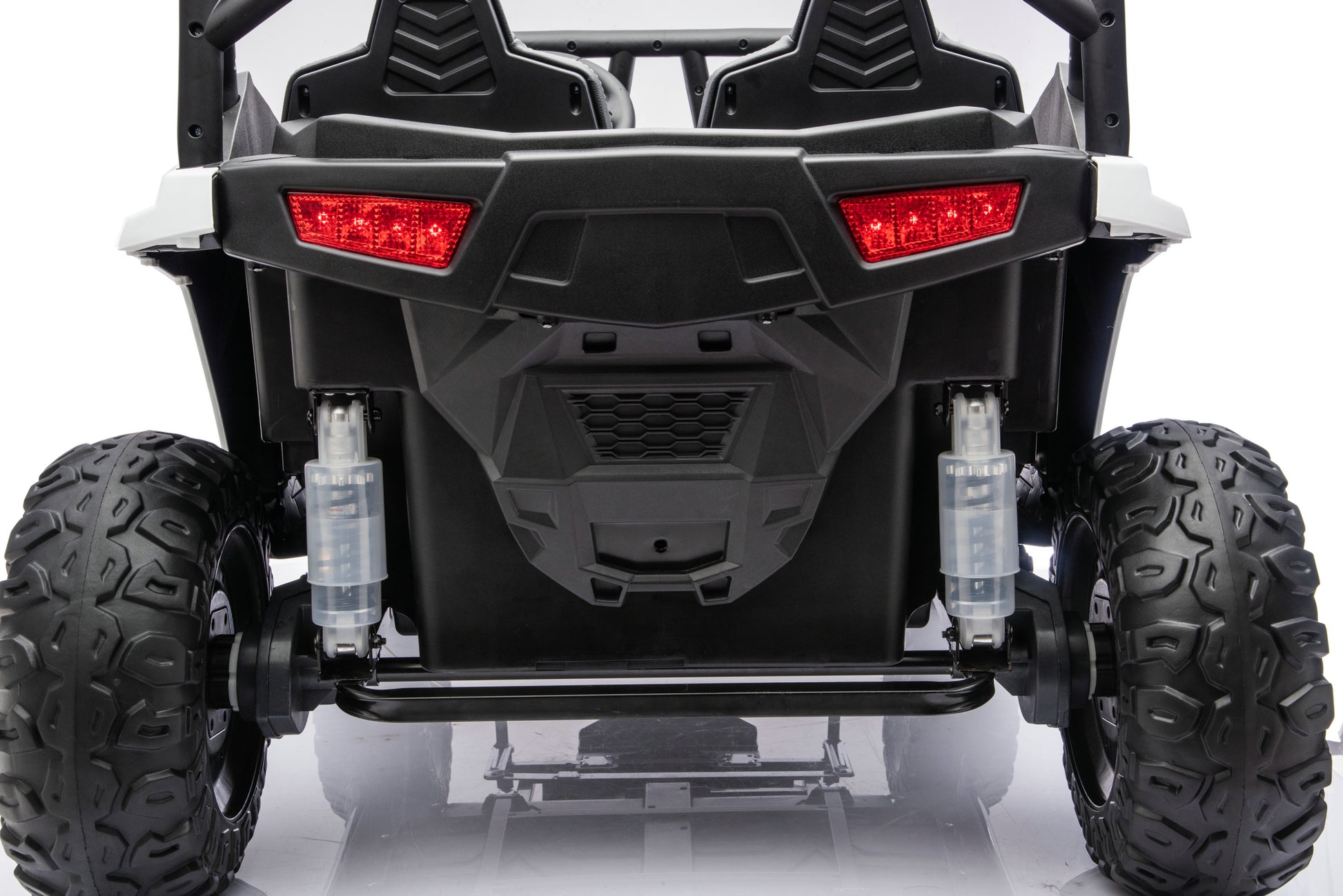 Rear view of a black and white off-road utility vehicle with large knobby tires, red taillights, and visible suspension components on a white studio background.