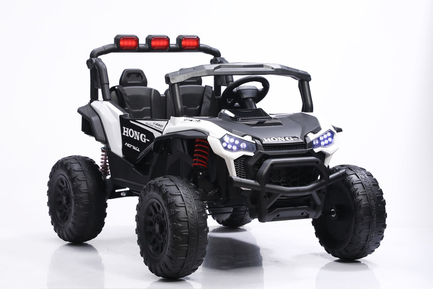 A black and white Honda UTV-style ride-on toy vehicle with large off-road tires, a roll cage, red light bar, and blue LED headlights, photographed on a clean white studio background.